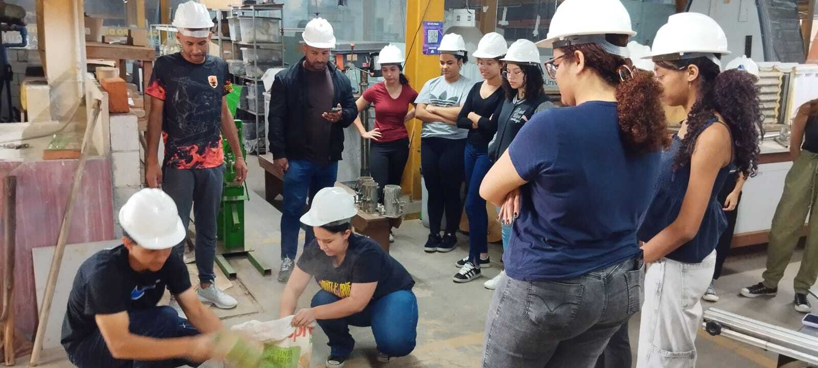 Grupo de estudantes com capacetes em atividade prática